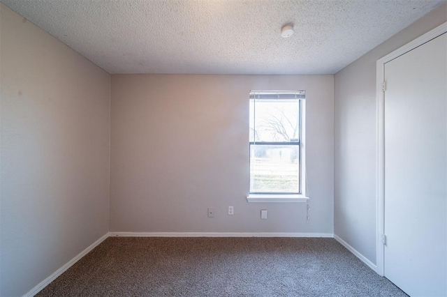 spare room with a textured ceiling and carpet flooring