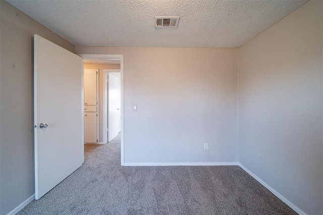 unfurnished room with light carpet and a textured ceiling