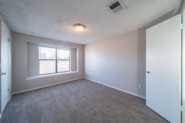 carpeted spare room featuring a textured ceiling