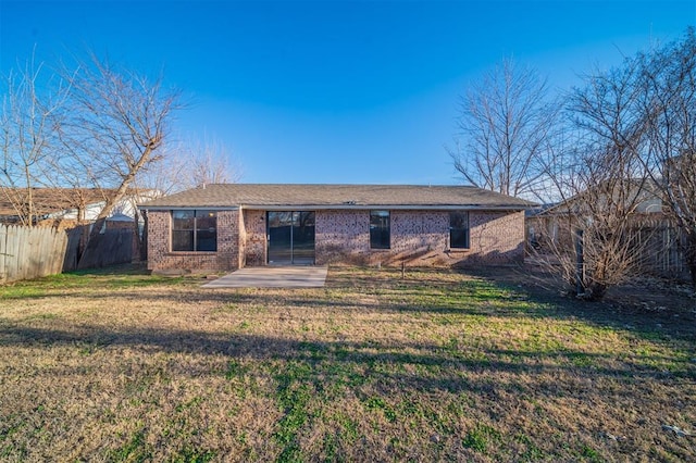 rear view of house with a yard and a patio