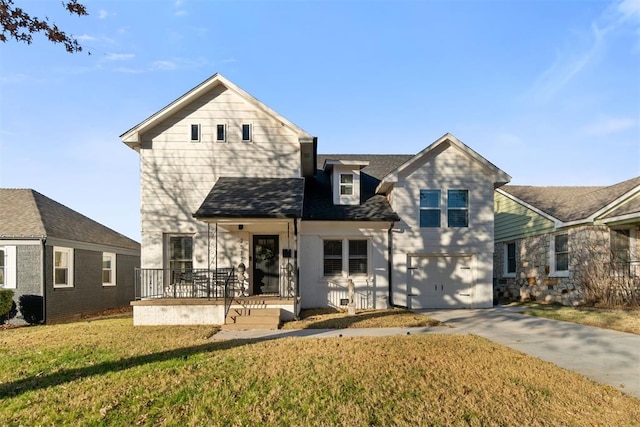 view of front property with covered porch, a garage, and a front yard