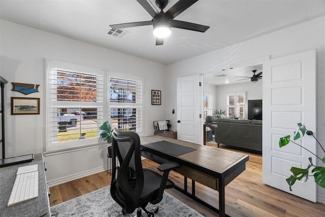 home office with ceiling fan, hardwood / wood-style floors, and a healthy amount of sunlight