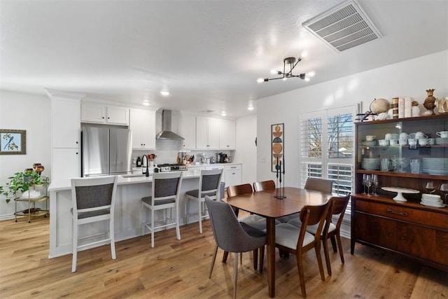 dining area featuring a chandelier, light hardwood / wood-style floors, and sink