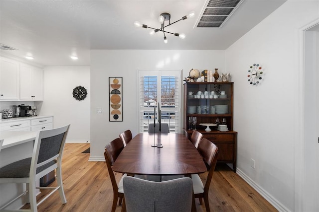 dining area with a notable chandelier and light wood-type flooring