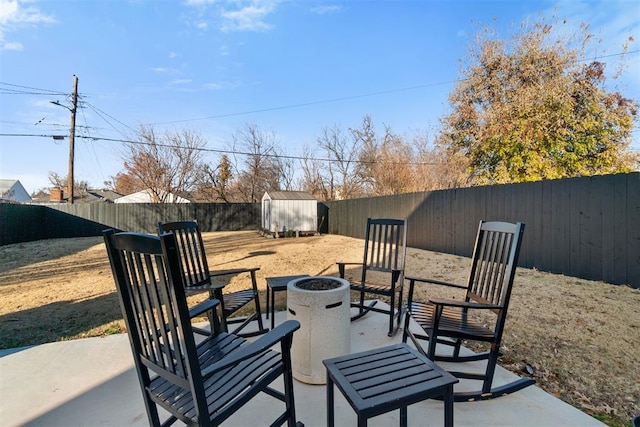 view of patio with a fire pit and a storage unit