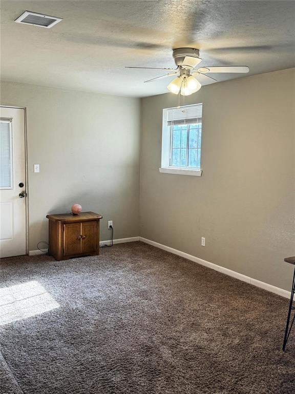 spare room featuring visible vents, a ceiling fan, carpet flooring, a textured ceiling, and baseboards