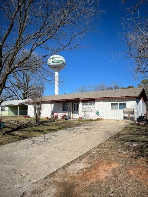 ranch-style home featuring concrete driveway and a chimney