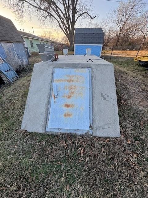 entry to storm shelter with an outbuilding and a shed