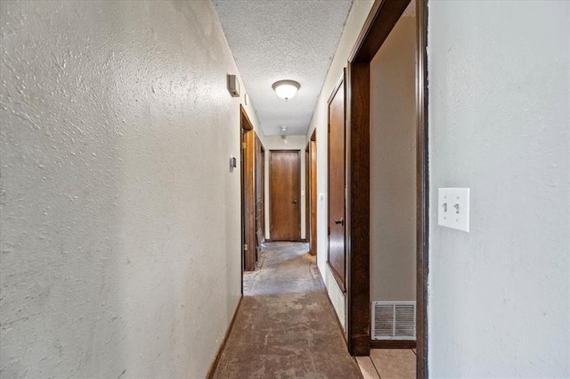 hall featuring a textured ceiling