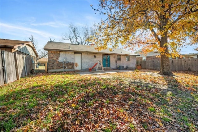 rear view of house featuring a patio, central AC unit, and a lawn