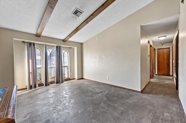 unfurnished room featuring beam ceiling and a textured ceiling