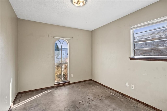 unfurnished room with concrete floors and a textured ceiling