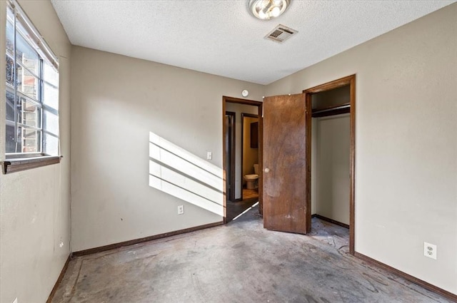 unfurnished bedroom with a closet, concrete flooring, and a textured ceiling