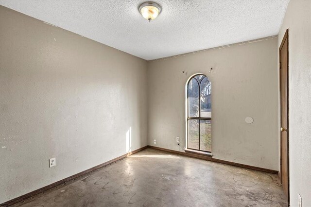 spare room with concrete floors and a textured ceiling