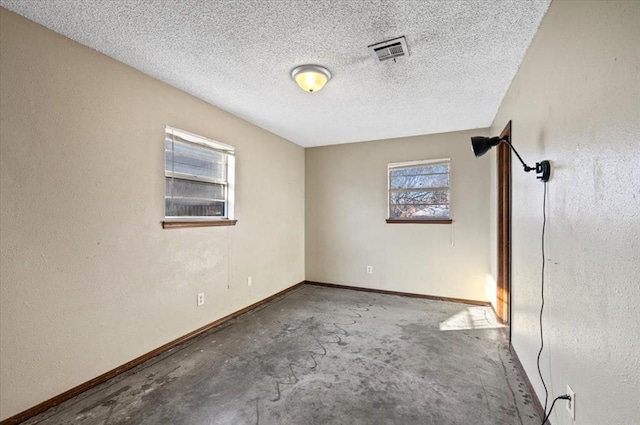 unfurnished room with concrete flooring and a textured ceiling