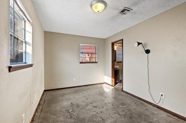 unfurnished room featuring concrete flooring and a textured ceiling