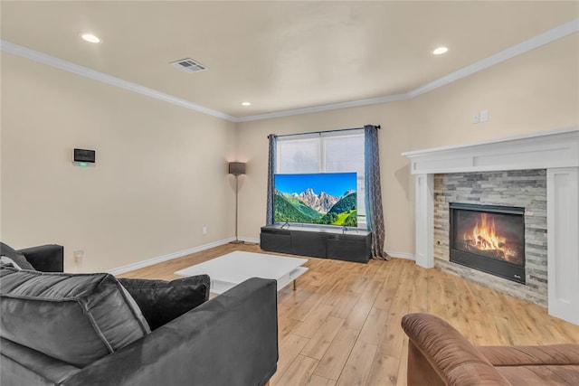 living room with light hardwood / wood-style flooring, crown molding, and a stone fireplace