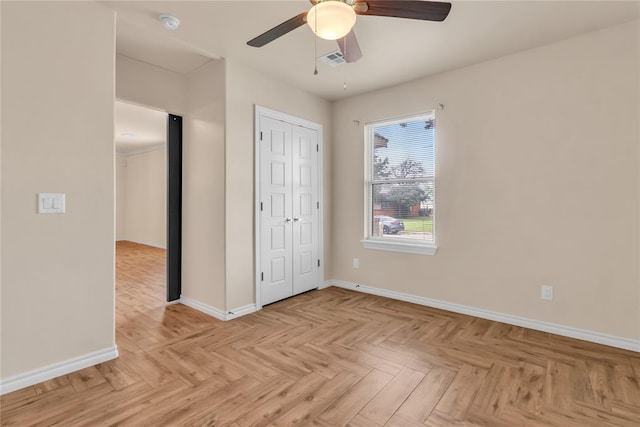 unfurnished bedroom with ceiling fan, a closet, and light parquet floors