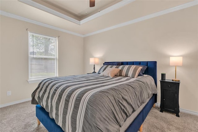 carpeted bedroom featuring a tray ceiling, ceiling fan, and crown molding