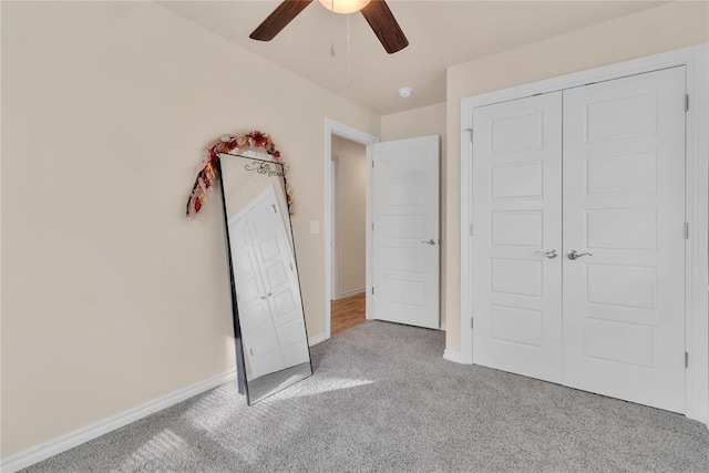 unfurnished bedroom featuring ceiling fan, light colored carpet, and a closet