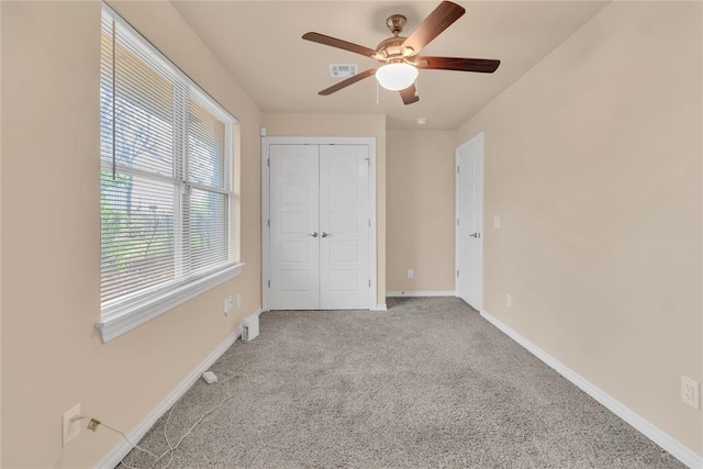 unfurnished bedroom featuring light carpet, a closet, and ceiling fan