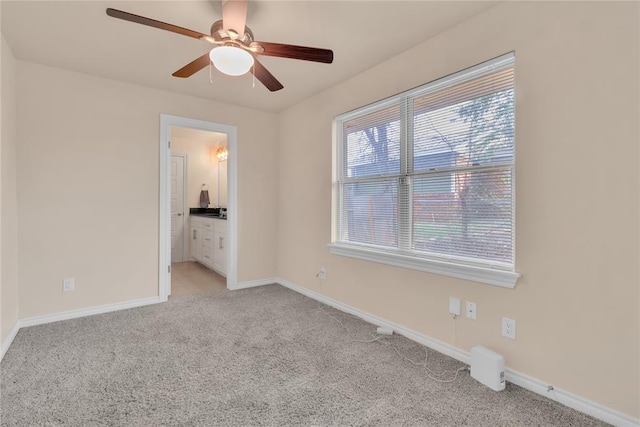 carpeted spare room with ceiling fan