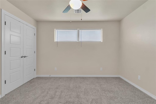 unfurnished bedroom with ceiling fan, a closet, and light colored carpet