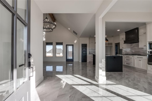 entryway with high vaulted ceiling and a notable chandelier