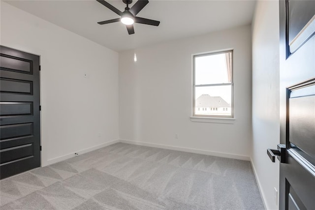 empty room featuring ceiling fan and light colored carpet