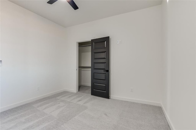 unfurnished bedroom featuring light carpet, a closet, and ceiling fan