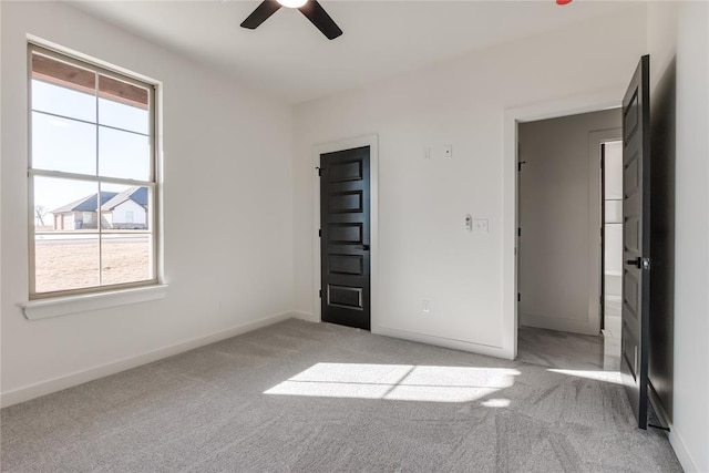 unfurnished bedroom with ceiling fan, light carpet, and multiple windows