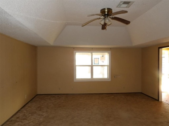 carpeted spare room featuring lofted ceiling, ceiling fan, and a textured ceiling