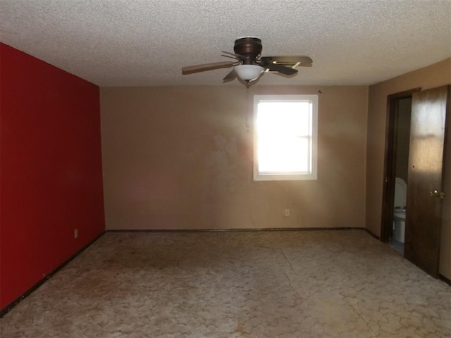 empty room with ceiling fan, carpet floors, and a textured ceiling