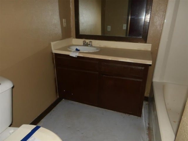 bathroom featuring a bathtub, vanity, and toilet