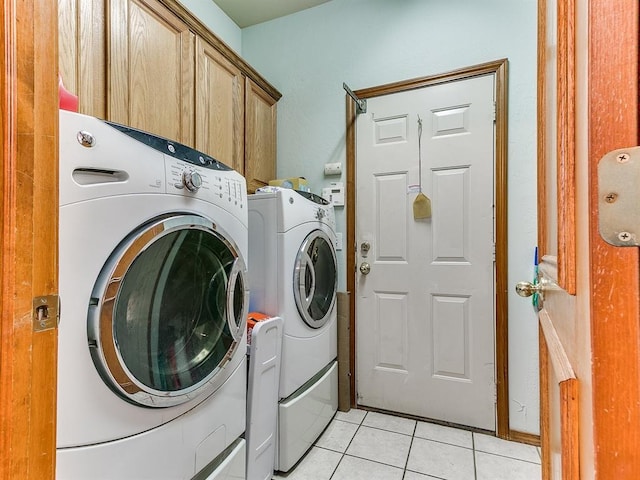 laundry room featuring light tile patterned flooring, cabinets, and independent washer and dryer