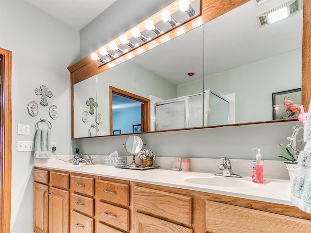 bathroom featuring vanity and an enclosed shower