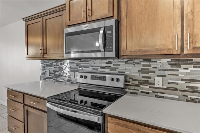 kitchen featuring light tile patterned flooring, stainless steel appliances, and backsplash