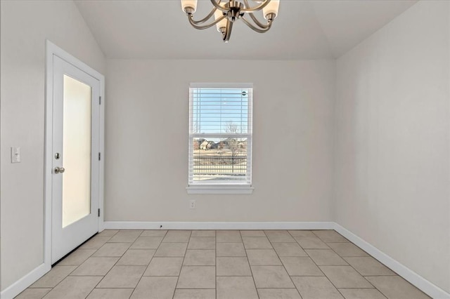 empty room with light tile patterned floors and a notable chandelier