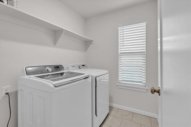 laundry area with light tile patterned floors and washing machine and dryer