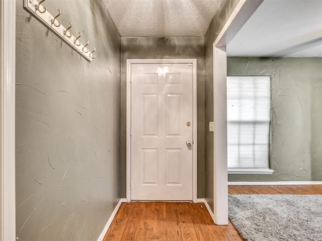 doorway featuring a textured ceiling and hardwood / wood-style flooring