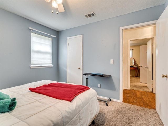 bedroom with carpet flooring, ceiling fan, and a textured ceiling