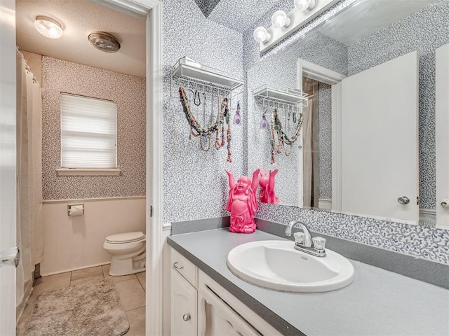 bathroom with tile patterned flooring, vanity, and toilet