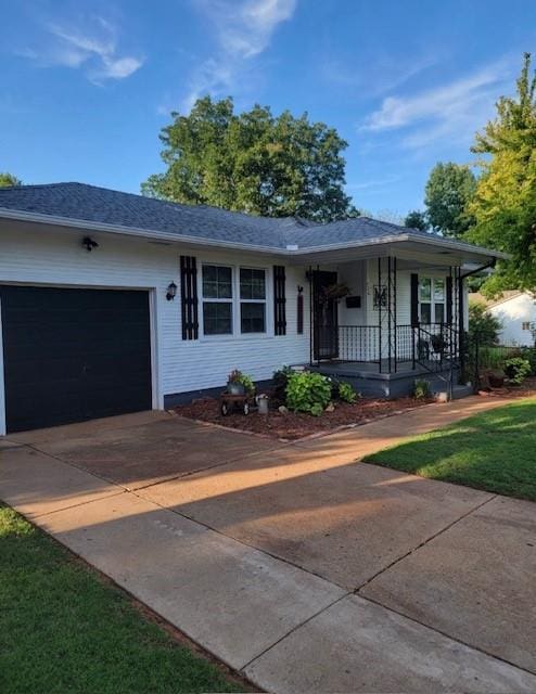 single story home featuring a front yard, a porch, and a garage