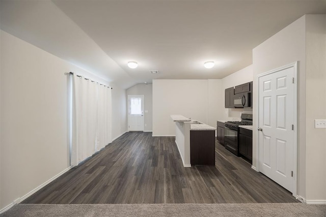 kitchen with dark hardwood / wood-style floors, vaulted ceiling, and black appliances