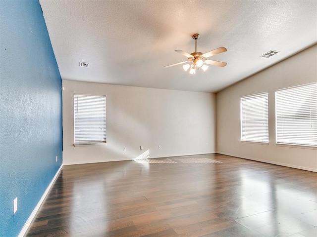 unfurnished room with ceiling fan, dark hardwood / wood-style flooring, and a textured ceiling