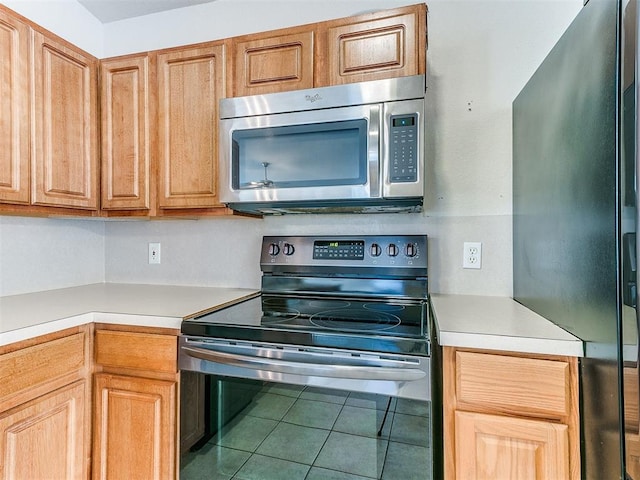 kitchen with tile patterned flooring and appliances with stainless steel finishes