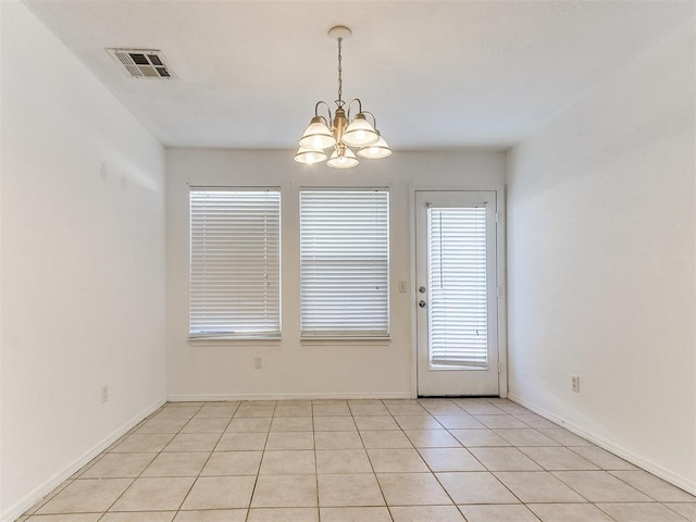 unfurnished dining area featuring light tile patterned floors and a chandelier