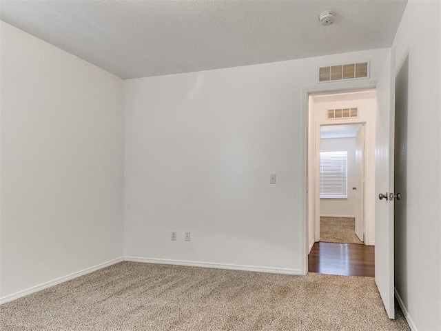 carpeted spare room featuring a textured ceiling