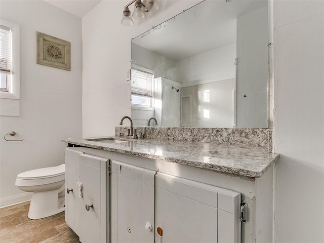 bathroom with hardwood / wood-style floors, vanity, and toilet