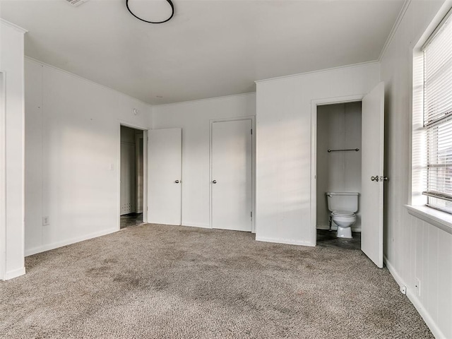 unfurnished bedroom featuring carpet floors, ensuite bath, and ornamental molding